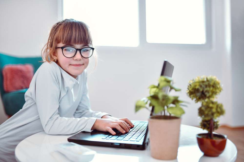 child in glasses by computer