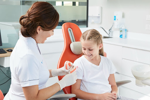 A dentist discusses tooth decay with child patient