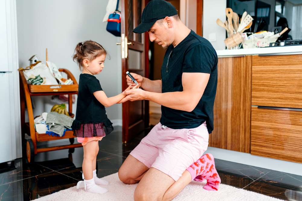 father checking blood sugar levels