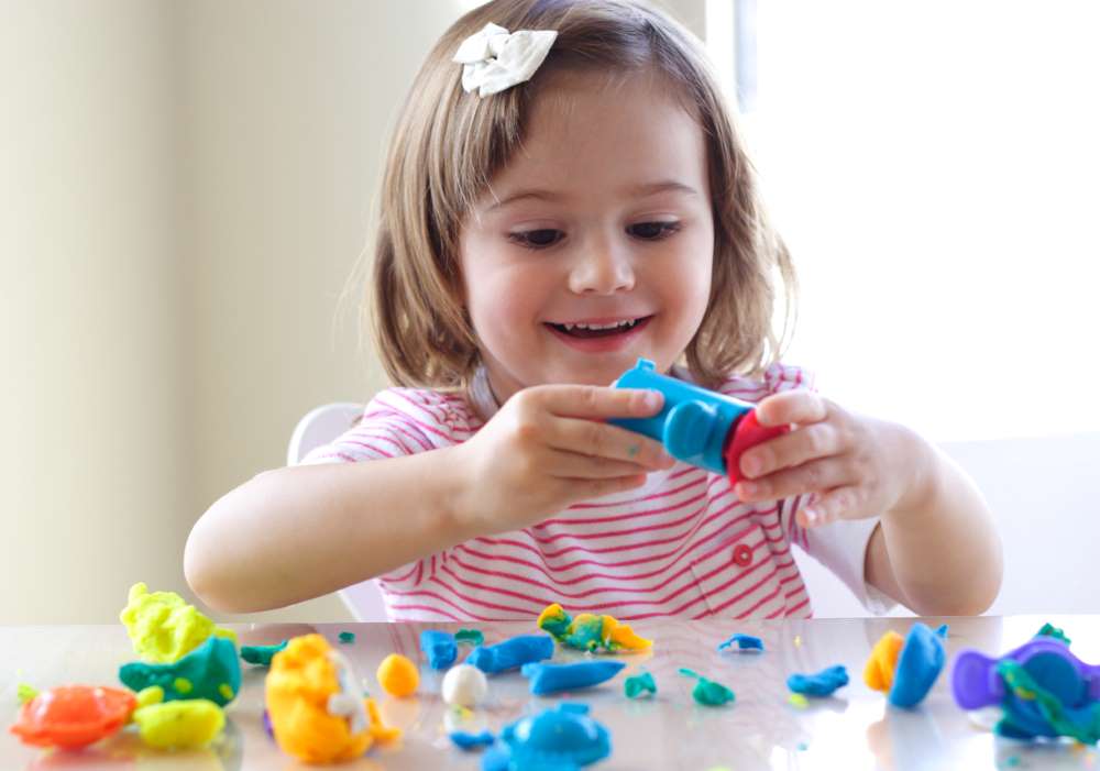 little girl is having fun with playdoh