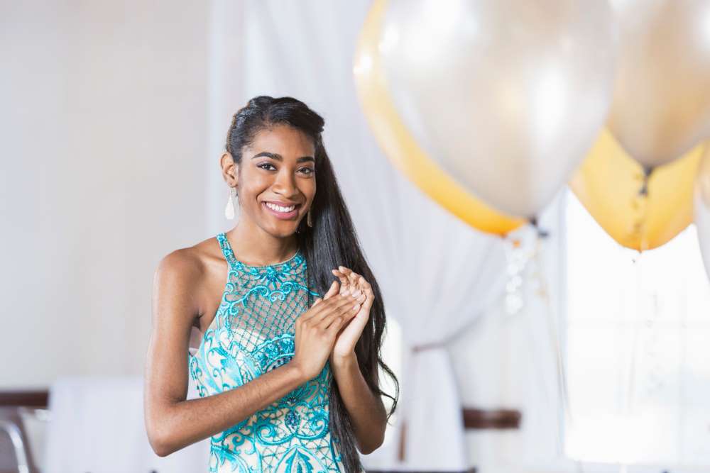 Smiling teenage girl in a formal dress getting ready for a school dance