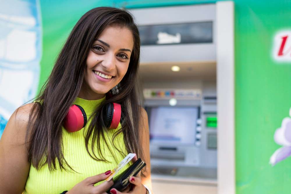 student taking money from atm