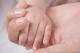 baby holding moms hand
