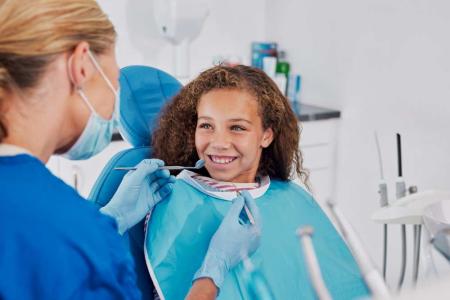 child smiling with braces at the dentist