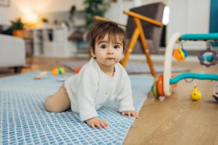 Toddler crawling and playing with toys