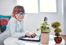 child in glasses by computer