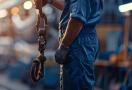 a plumber in a professional business uniform checking his service equipment tied to an anchor.