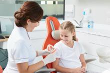 A dentist discusses tooth decay with child patient