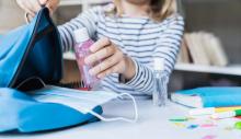 kid packing hand sanitizer at school