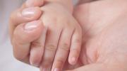 baby holding moms hand